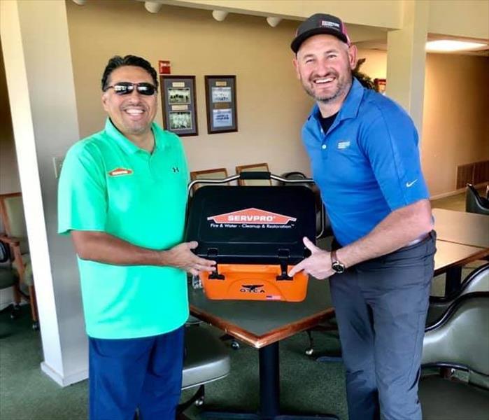 Two people holding the winning cooler prize 