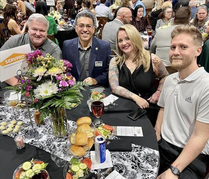 Group of people sitting at a table at a dinner awards event 