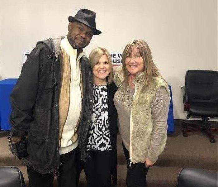 Three people posing for a picture at a business event.