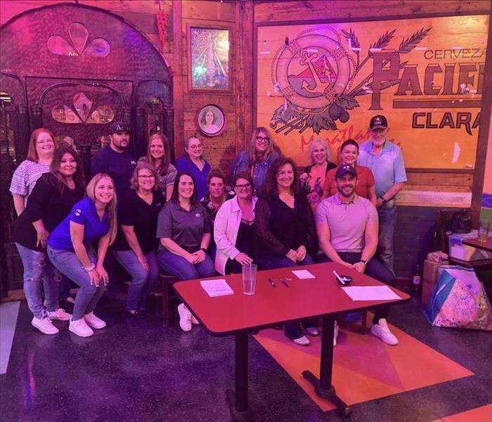 Group of people posing for a picture at a restaurant 