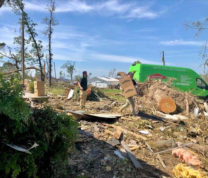 A SERVPRO employee surveying damage to a home.