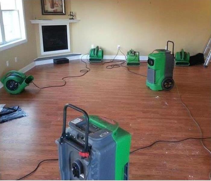 A SERVPRO fan in the living room of a home that has been flooded and is now drying.