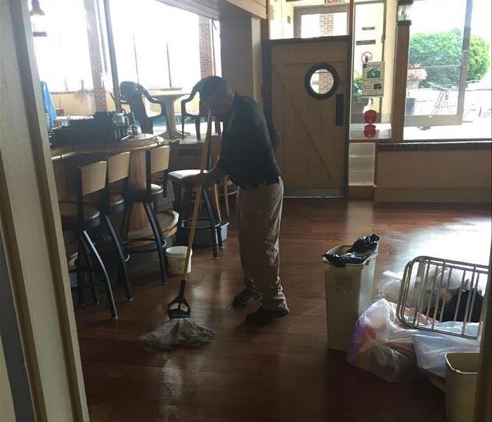 A SERVPRO employee surveying damage to a home.