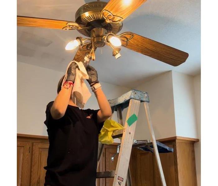 SERVPRO technician cleaning ceiling fan