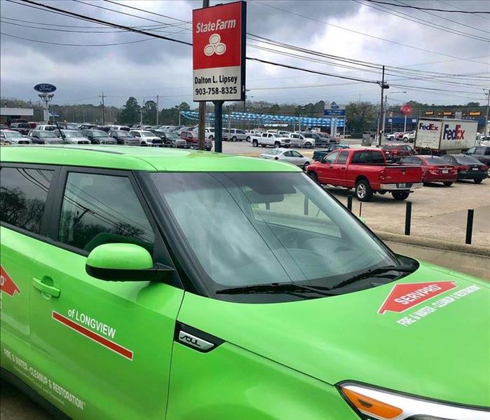 A SERVPRO vehicle parked in front of a customer's business.