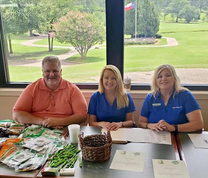 3 People posing for a picture at a golf course.