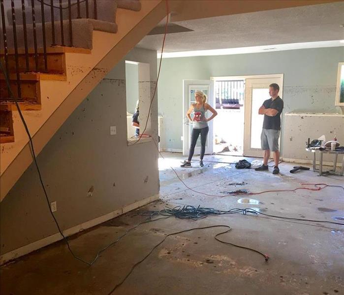 Unhappy Homeowners inspect their flood damaged home